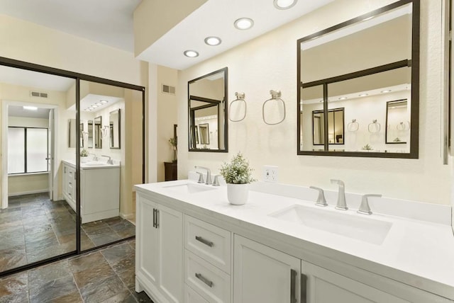 4535 Chateau Dr, San Diego, CA 92117 - full bathroom with stone tile floors, double vanity, baseboards, and recessed lighting