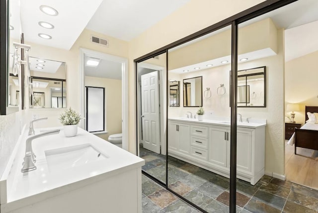 4535 Chateau Dr, San Diego, CA 92117 - bathroom with stone tile floors, double vanity, toilet, and baseboards
