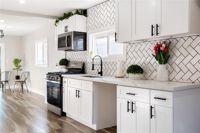 4930 W 142nd St, Hawthorne, CA 90250 - kitchen featuring appliances with stainless steel finishes, a sink, wood finished floors, white cabinets, and recessed lighting