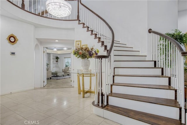 18238 Hastings Way, Porter Ranch, CA 91326 - stairway with a high ceiling, baseboards, arched walkways, a chandelier, and tile patterned flooring