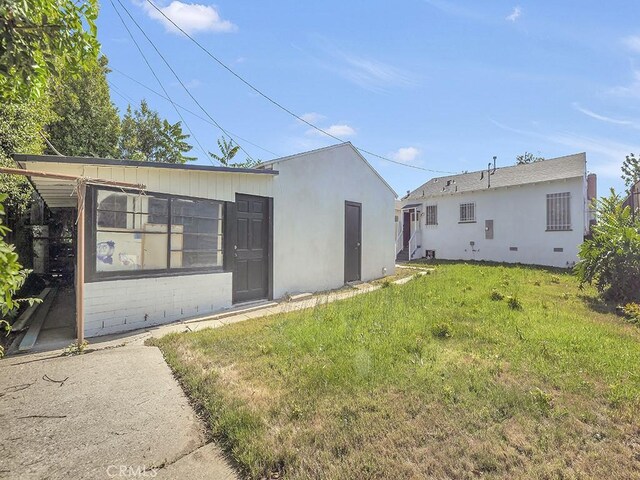 8830 Ruthelen St, Los Angeles, CA 90047 - back of house with a yard and stucco siding