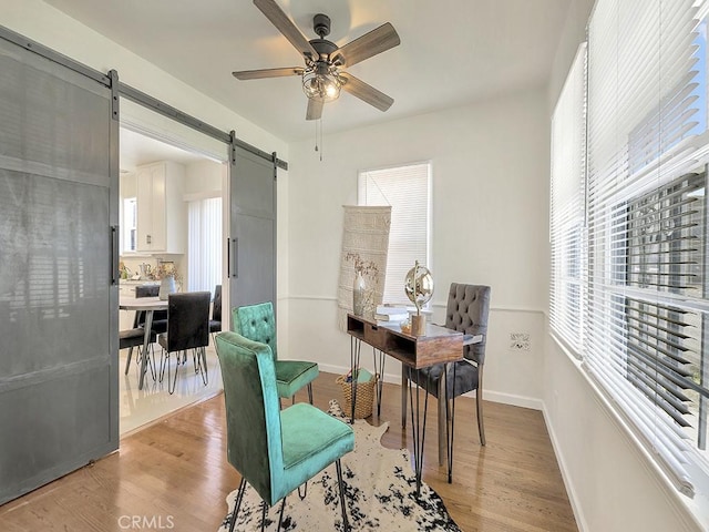 8830 Ruthelen St, Los Angeles, CA 90047 - office space with a barn door, a ceiling fan, light wood-type flooring, and baseboards