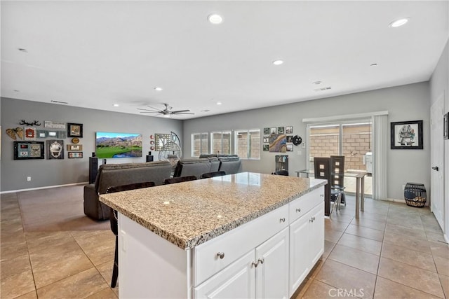 42667 Gazapo Ct, Indio, CA 92203 - kitchen with light tile patterned floors, ceiling fan, a center island, recessed lighting, and white cabinets