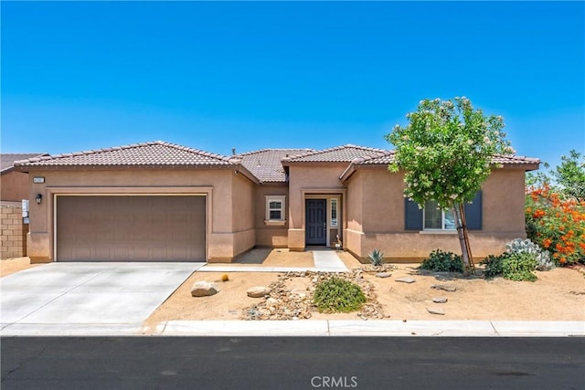 42667 Gazapo Ct, Indio, CA 92203 - view of front of house featuring an attached garage, stucco siding, driveway, and a tile roof