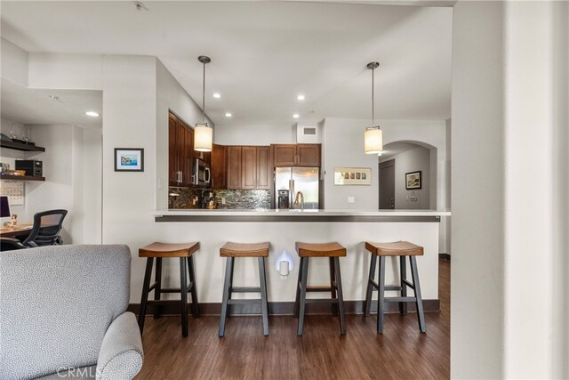 24585 Town Center Dr Unit 4308, Valencia, CA 91355 - kitchen featuring appliances with stainless steel finishes, a breakfast bar area, recessed lighting, tasteful backsplash, and dark wood-style flooring