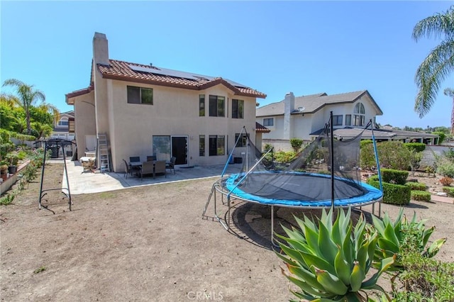 824 Leyland Dr, Diamond Bar, CA 91765 - back of property with a trampoline, roof mounted solar panels, stucco siding, a patio, and a tile roof