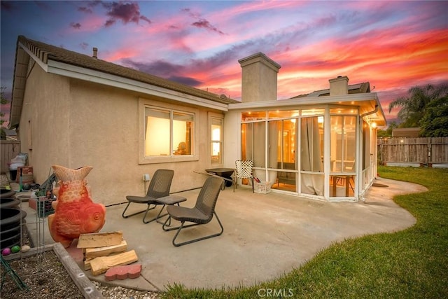143 Brisas St, Oceanside, CA 92058 - back of property at dusk with a patio, a chimney, a sunroom, and stucco siding
