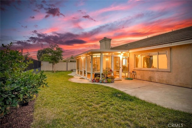 143 Brisas St, Oceanside, CA 92058 - back of house at dusk with a chimney, a sunroom, a patio, and stucco siding
