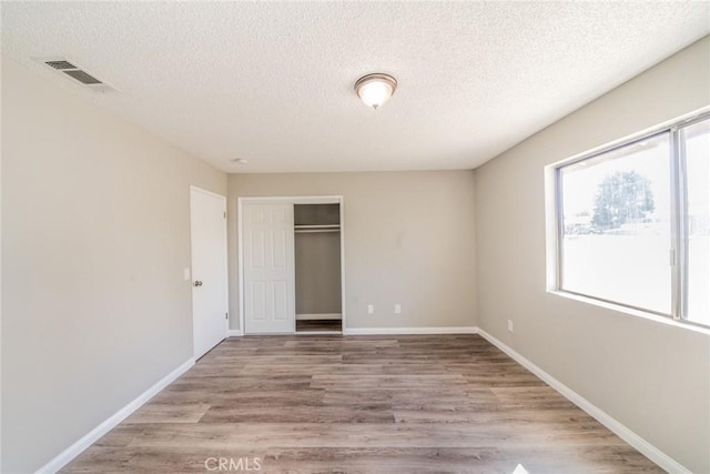 17470 Krameria Ave, Riverside, CA 92504 - unfurnished bedroom with a closet, a textured ceiling, and wood finished floors