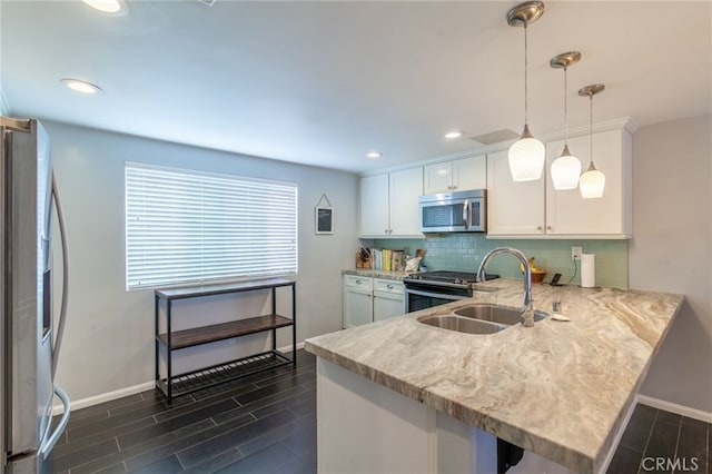 4357 W Sarah St Unit 26, Burbank, CA 91505 - kitchen with appliances with stainless steel finishes, baseboards, a sink, decorative backsplash, and a peninsula
