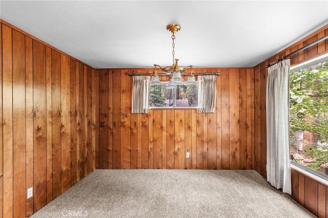 26972 State Highway 189, Blue Jay, CA 92317 - unfurnished dining area featuring healthy amount of natural light, a chandelier, carpet flooring, and wood walls