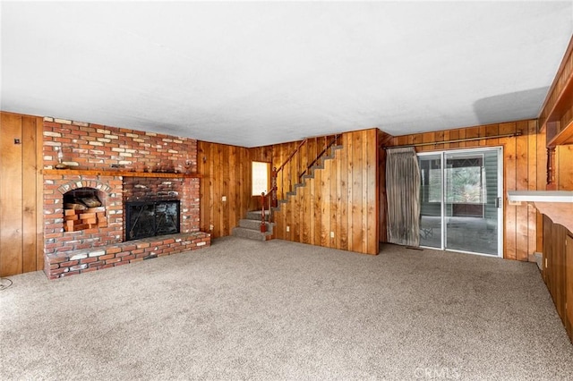 26972 State Highway 189, Blue Jay, CA 92317 - unfurnished living room featuring wood walls, a fireplace, carpet floors, and stairs