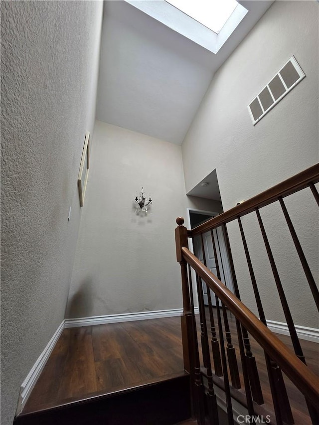 21901 Moneta Ave Unit 21, Carson, CA 90745 - staircase with a skylight, wood finished floors, high vaulted ceiling, baseboards, and a textured wall