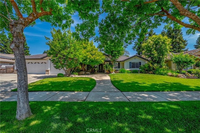 625 Redwing Dr, Merced, CA 95340 - view of front of property with a front yard, concrete driveway, an attached garage, and stucco siding