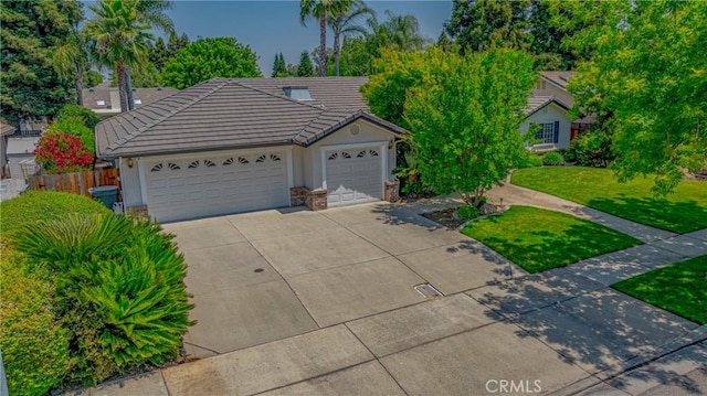 625 Redwing Dr, Merced, CA 95340 - view of front of house featuring concrete driveway, a tiled roof, an attached garage, and stone siding