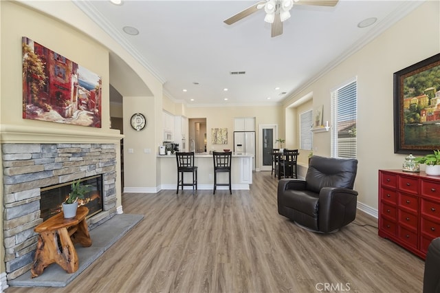 23463 Canterbury Way, Murrieta, CA 92562 - living room with light wood-type flooring, ceiling fan, a fireplace, crown molding, and recessed lighting