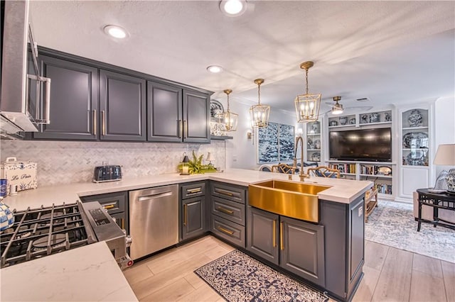 25536 Rue Terrase Unit 17, Laguna Niguel, CA 92677 - kitchen with a peninsula, stainless steel appliances, tasteful backsplash, decorative light fixtures, and open floor plan