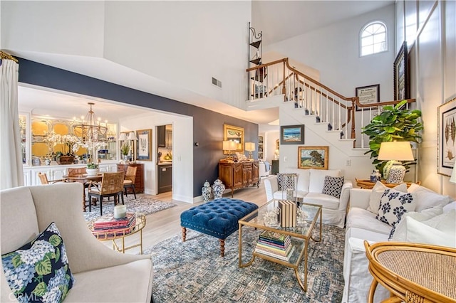 25536 Rue Terrase Unit 17, Laguna Niguel, CA 92677 - living room featuring a towering ceiling, light wood finished floors, stairway, and a chandelier