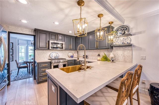 25536 Rue Terrase Unit 17, Laguna Niguel, CA 92677 - kitchen featuring appliances with stainless steel finishes, light wood-style floors, a chandelier, a peninsula, and recessed lighting