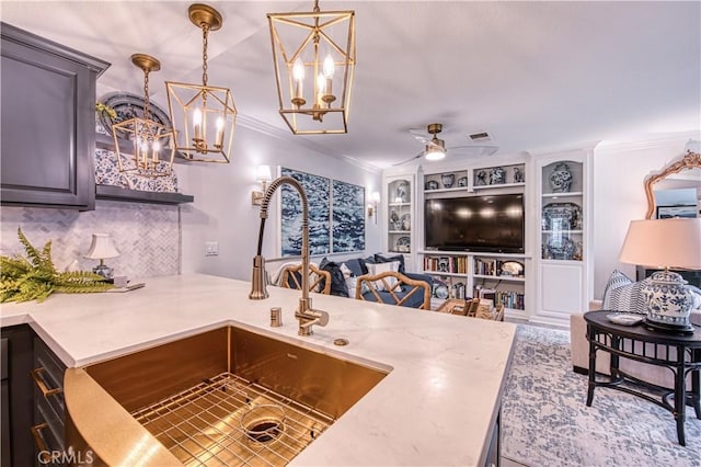 25536 Rue Terrase Unit 17, Laguna Niguel, CA 92677 - kitchen featuring ornamental molding, a chandelier, decorative backsplash, a ceiling fan, and light countertops