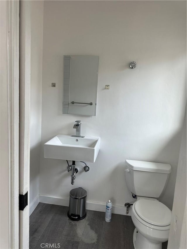 45208 17th St W, Lancaster, CA 93534 - half bath featuring toilet, baseboards, wood finished floors, and a sink