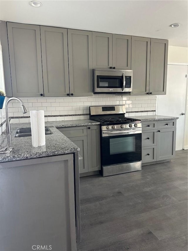 45208 17th St W, Lancaster, CA 93534 - kitchen featuring appliances with stainless steel finishes, gray cabinetry, light stone countertops, tasteful backsplash, and recessed lighting