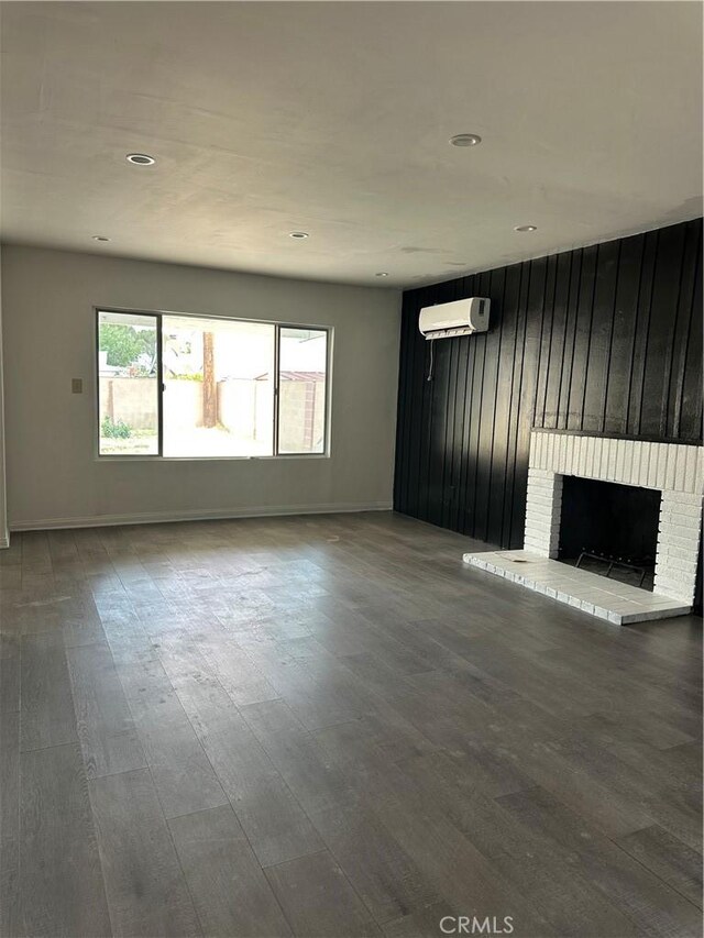 45208 17th St W, Lancaster, CA 93534 - unfurnished living room with an AC wall unit, a fireplace, wood finished floors, and recessed lighting