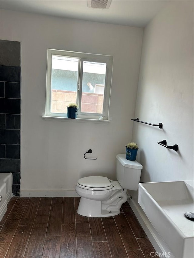 45208 17th St W, Lancaster, CA 93534 - bathroom with wood finish floors, toilet, and baseboards