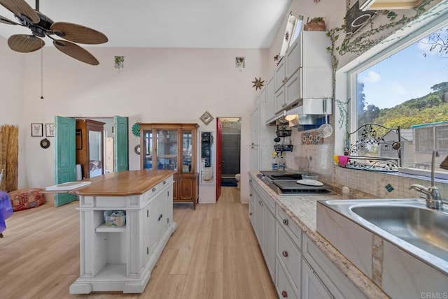 2620 Mar Vinga, Fallbrook, CA 92028 - kitchen with cooktop, a sink, a ceiling fan, light wood-style flooring, and a towering ceiling