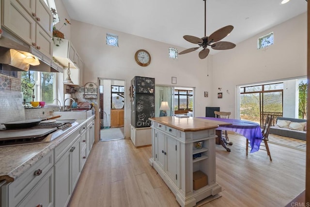 2620 Mar Vinga, Fallbrook, CA 92028 - kitchen with high vaulted ceiling, a sink, cooktop, light wood finished floors, and ceiling fan