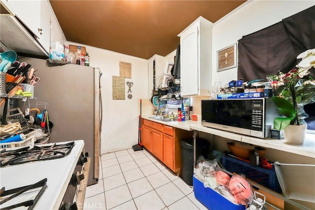 333 W D St, Wilmington, CA 90744 - kitchen with white gas stove, light tile patterned floors, light countertops, and white cabinets