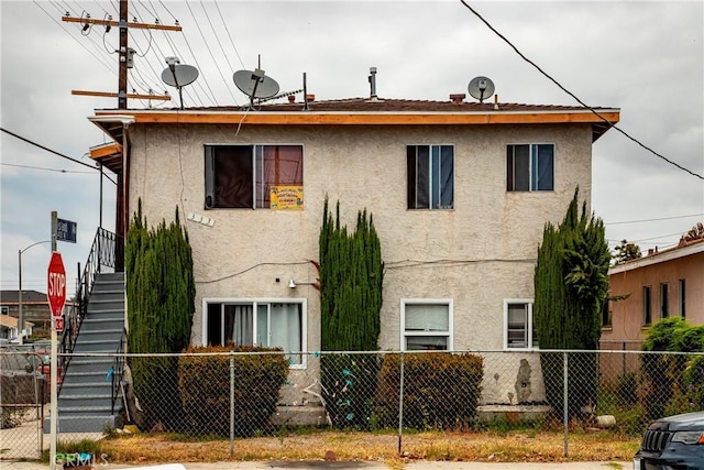 333 W D St, Wilmington, CA 90744 - rear view of property with stucco siding, stairs, and a fenced front yard