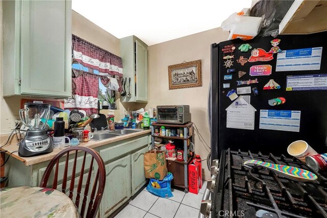 333 W D St, Wilmington, CA 90744 - kitchen with freestanding refrigerator, a sink, light tile patterned floors, and green cabinetry