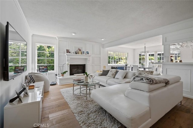 4420 Conchita Way, Tarzana, CA 91356 - living room featuring a textured ceiling, a glass covered fireplace, wood finished floors, and crown molding