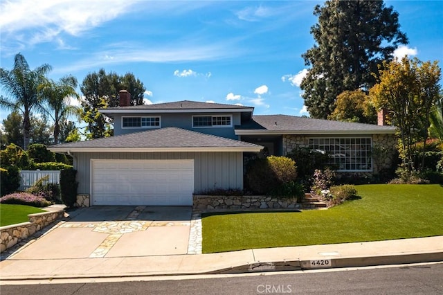 4420 Conchita Way, Tarzana, CA 91356 - tri-level home with a chimney, an attached garage, driveway, and stone siding