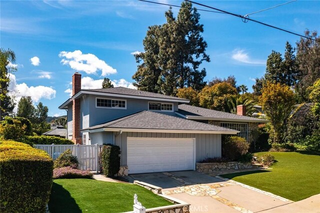 4420 Conchita Way, Tarzana, CA 91356 - view of front of home featuring a chimney, a garage, a shingled roof, and concrete driveway
