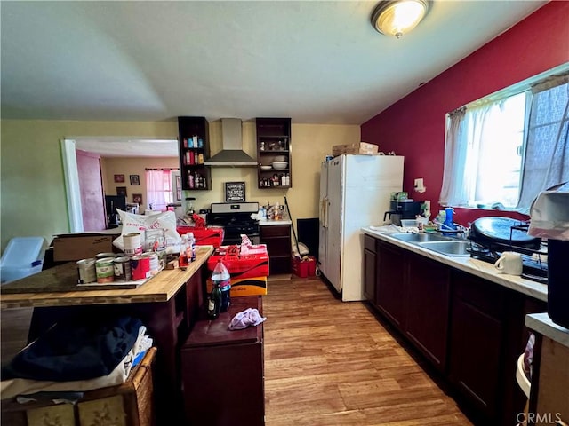 9547 Marion Ave, Montclair, CA 91763 - kitchen featuring wall chimney exhaust hood, stainless steel gas stove, light wood-type flooring, a sink, and freestanding refrigerator