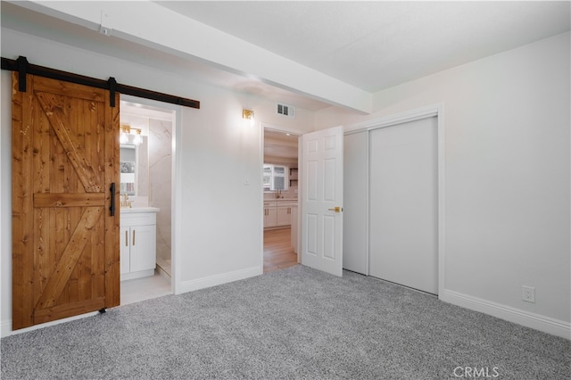 8235 Coleman St, Riverside, CA 92504 - unfurnished bedroom featuring a barn door, carpet, a closet, and baseboards