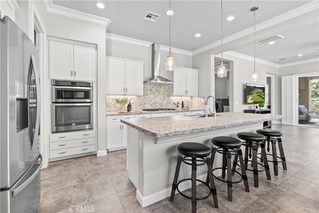 147 Luneta Ln, Rancho Mission Viejo, CA 92694 - kitchen featuring stainless steel appliances, wall chimney exhaust hood, a sink, backsplash, and a kitchen island with sink