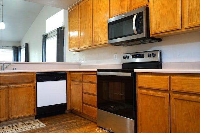 2068 Spy Glass Ct, Merced, CA 95340 - kitchen with stainless steel appliances, dark wood-type flooring, light countertops, brown cabinets, and lofted ceiling