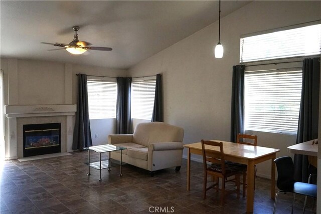 2068 Spy Glass Ct, Merced, CA 95340 - dining area featuring vaulted ceiling, plenty of natural light, a ceiling fan, stone finish floors, and a fireplace with flush hearth