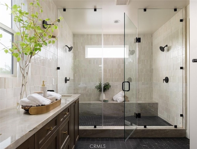 18017 Roch Ct, Fountain Valley, CA 92708 - bathroom with vanity, a shower stall, tile patterned flooring, tile walls, and decorative backsplash