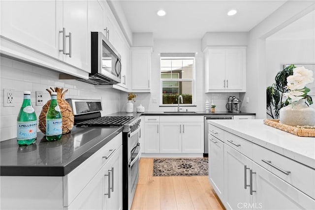28 Fosco St, Rancho Mission Viejo, CA 92694 - kitchen with stainless steel appliances, a sink, light wood-type flooring, white cabinets, and recessed lighting