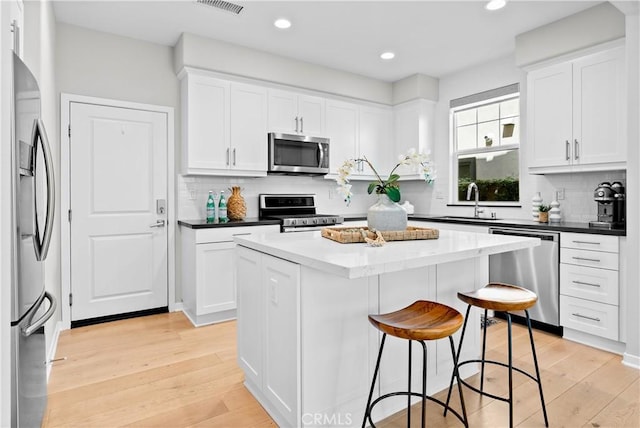 28 Fosco St, Rancho Mission Viejo, CA 92694 - kitchen with appliances with stainless steel finishes, a sink, a kitchen island, a kitchen bar, and white cabinets