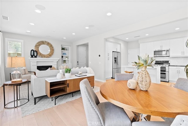 28 Fosco St, Rancho Mission Viejo, CA 92694 - dining area with recessed lighting, light wood-style flooring, a fireplace, built in features, and baseboards