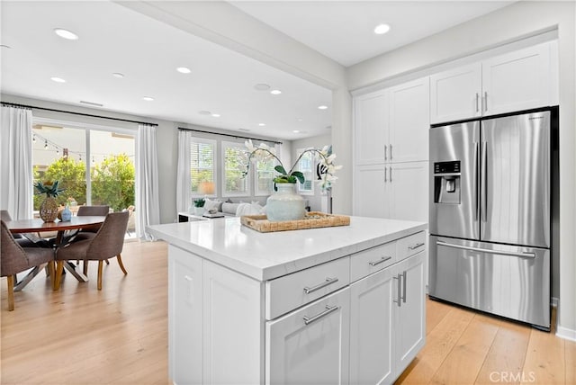 28 Fosco St, Rancho Mission Viejo, CA 92694 - kitchen with stainless steel fridge with ice dispenser, light wood finished floors, white cabinetry, recessed lighting, and a kitchen island