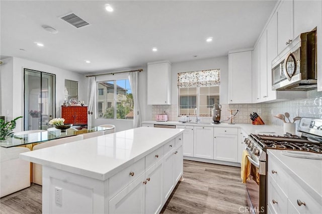 747 Spring Gdn, Irvine, CA 92618 - kitchen featuring stainless steel appliances, light wood-style flooring, decorative backsplash, light countertops, and recessed lighting