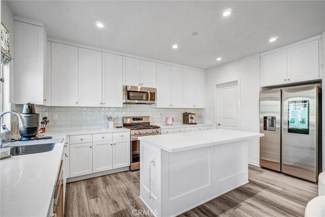 747 Spring Gdn, Irvine, CA 92618 - kitchen featuring appliances with stainless steel finishes, a sink, light wood-type flooring, white cabinetry, and backsplash