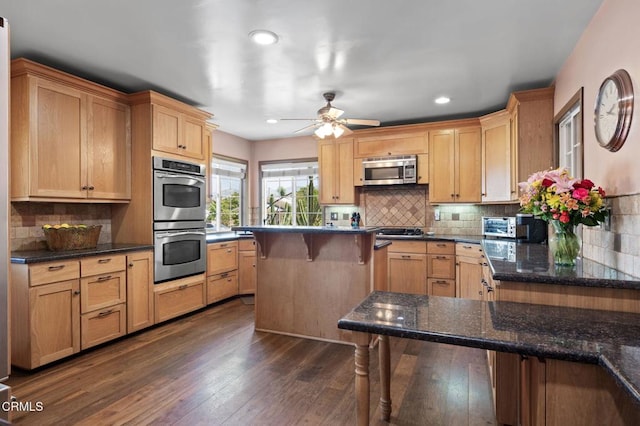 339 2nd St, Fillmore, CA 93015 - kitchen with appliances with stainless steel finishes, backsplash, a ceiling fan, dark wood finished floors, and a kitchen bar