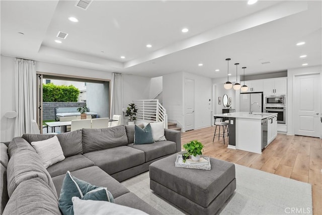 40 Jarano St, Rancho Mission Viejo, CA 92694 - living room with stairway, recessed lighting, light wood-style floors, and a raised ceiling